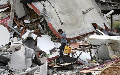 A Palestinian boy walks through the rubble of a destroyed building following an Israeli air strike in Jabaliya, on Monday (photo credit: AP Photo/Adel Hana)