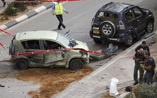 Police engineers examine the site where a rocket landed in Ashdod on Monday. (photo credit: AP) Police engineers examine the site where a rocket landed in Ashdod on Monday. (photo credit: AP)