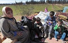 A Syrian woman who fled from the Syrian town of Qusair, near Homs, is seen with her family at the Lebanese-Syrian border village of Qaa, Monday, March 5, 2012. (photo credit: AP Photo/Hussein Malla)