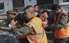 Syrian rescue crews carry a man injured in Damascus on Saturday (photo credit: AP)