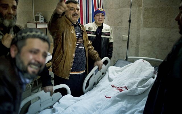 Relatives mourn the death of a victim of a Syrian Army sniper on Wednesday (photo credit: AP/Rodrigo Abd)