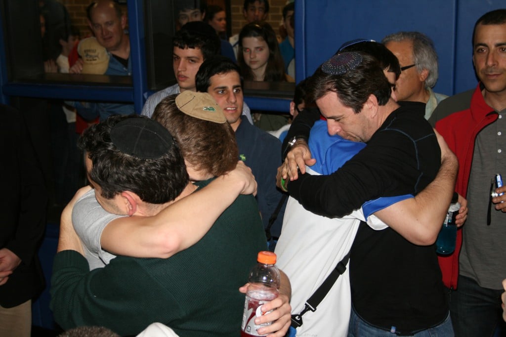 Yair Miller, left, and Ahron Guttman seek comfort from their fathers after losing the championship game. (Photo credit: Samantha Steinberg/JTA)