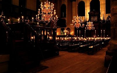Amsterdam has a rich Jewish history, including architecture. Pictured is the interior of Amsterdam's Portuguese Synagogue illuminated by candlelight. (photo credit: CC BY-SA Massimo Catarinella, Wikimedia)