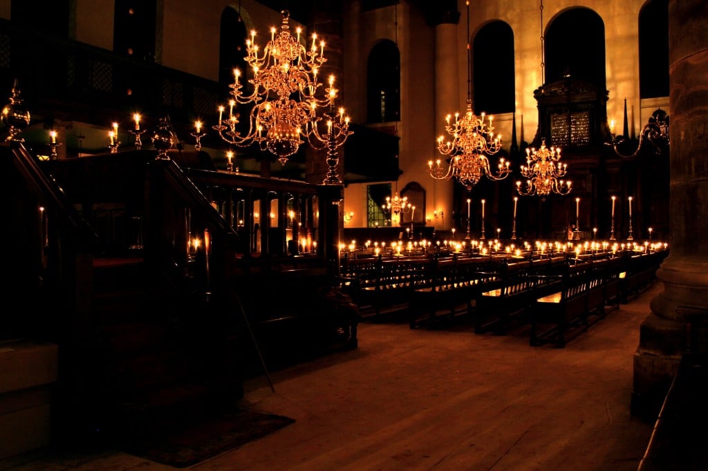 Interior of Amsterdam's Portuguese Synagogue illuminated by candlelight. (photo credit: CC BY-SA Massimo Catarinella, Wikimedia)