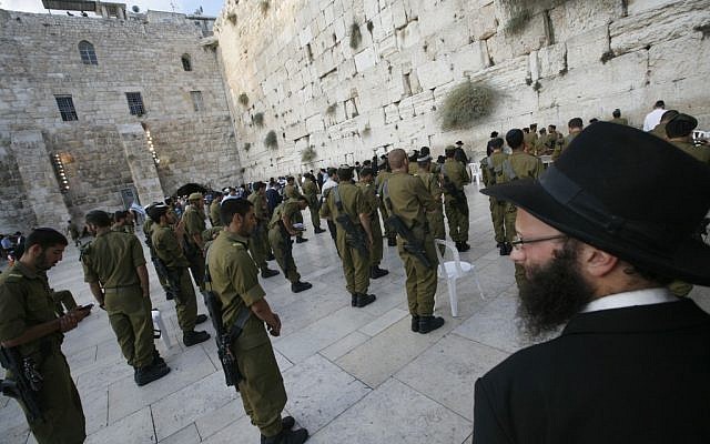 An ultra-Orthodox man looks at Golani soldiers praying at the Western Wall (photo credit: Miriam Alster/Flash90) An ultra-Orthodox man looks at Golani soldiers praying at the Western Wall (photo credit: Miriam Alster/Flash90)