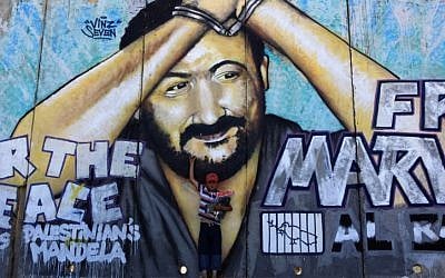 A Palestinian child stands in front of a mural of jailed Palestinian leader Marwan Barghouti at the Kalandia checkpoint between the West Bank city of Ramallah and Jerusalem. (Kobi Gideon/Flash 90)