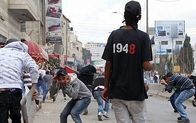 Stone hurling Palestinians clash with Israeli troops near the Qalandiya checkpoint on 'Nakba Day' last May. (photo credit: Nati Shohat/Flash90)