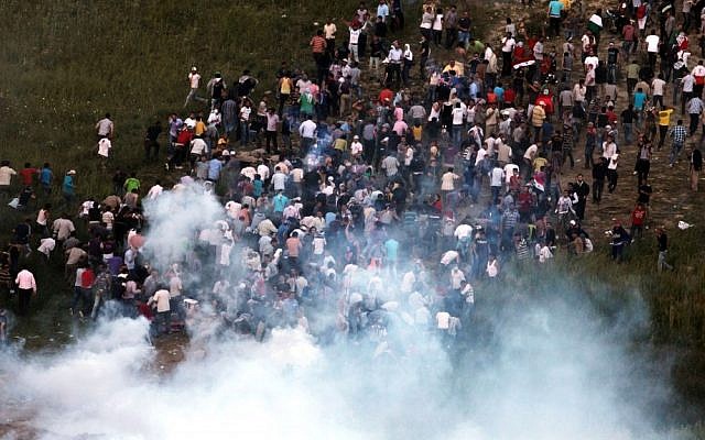 Demonstrators gather along Syria's border with Israel before trying to cut through a line of barbed wire and head into the Golan Heights, as seen from the Druze village of Majdal Shams, on June 5 last year. (photo credit: Flash90)
