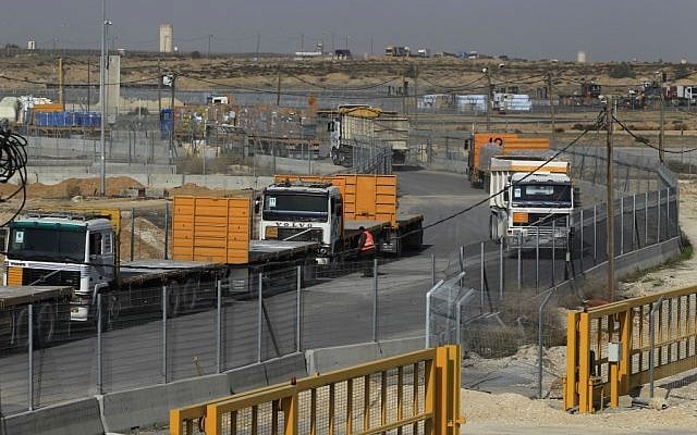 Empty trucks from Gaza wait to be loaded with goods (left) as full trucks drive toward Gaza in the background at the Kerem Shalom crossing between Israel and Gaza last year (photo credit: Tsafrir Abayov/Flash90)