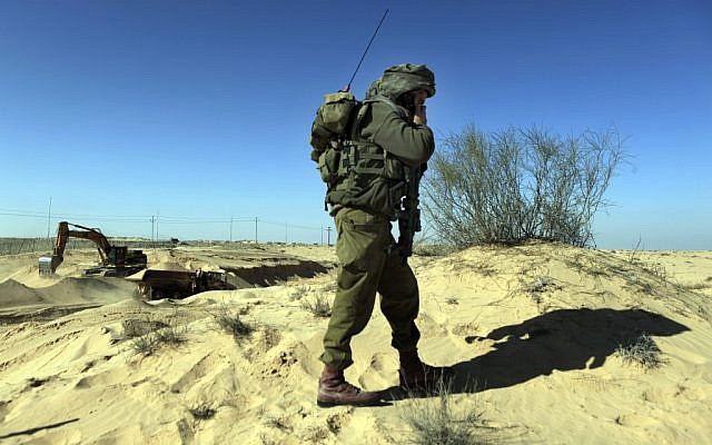 An IDF soldier secures works on the Israeli-Egyptian border fence. (Tsafrir Abayov/Flash90)