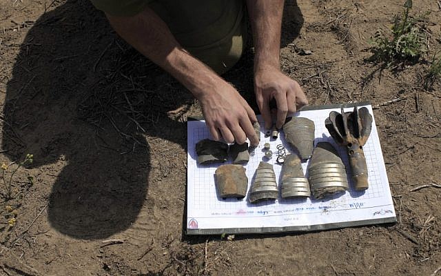 An IDF officer examines the remains  a mortar shell fired from the Gaza Strip in early March (photo credit: Tsafrir Abayov/Flash90)