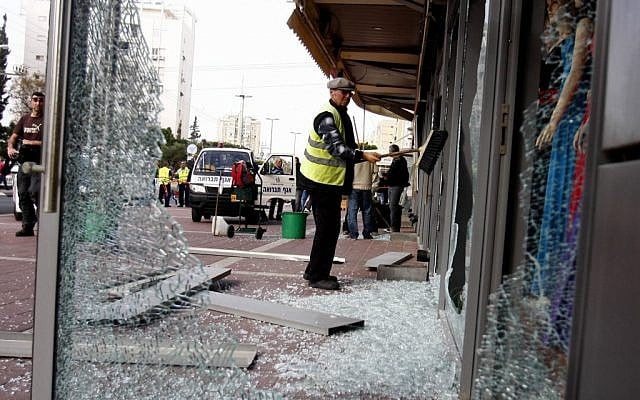 Cleaning up after a Grad rocket fired from Gaza hits the center of Ashdod last Monday. (photo credit: Flash90)* Cleaning up after a Grad rocket fired from Gaza hits the center of Ashdod last Monday. (photo credit: Flash90)*