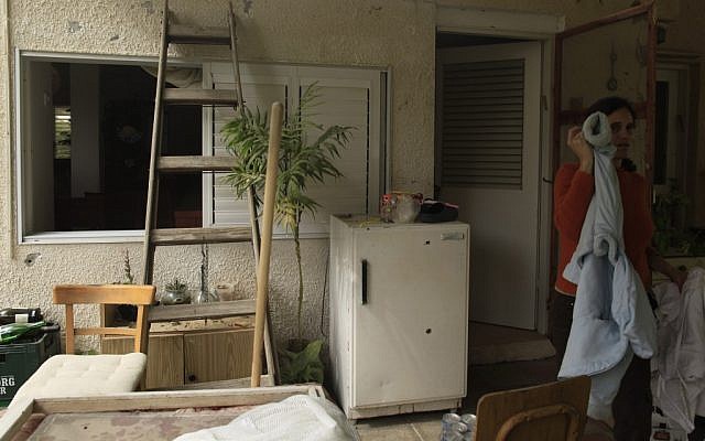 An Israeli woman stand near the entrance to her house in a Gaza border kibbutz, hit by a Kassam rocket earlier this week. (photo credit: Tsafrir Abayov/Flash90) An Israeli woman stand near the entrance to her house in a Gaza border kibbutz, hit by a Kassam rocket earlier this week. (photo credit: Tsafrir Abayov/Flash90)