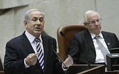 Prime Minister Benjamin Netanyahu speaks in the Knesset on Wednesday, with Knesset speaker Reuven Rivlin in the background. (photo credit: Miriam Alster/Flash90)