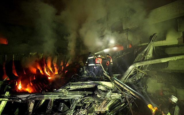 Palestinian firefighters attempt to extinguish a burning factory in Gaza on Wednesday (photo credit: Wissam Nassar/Flash90)