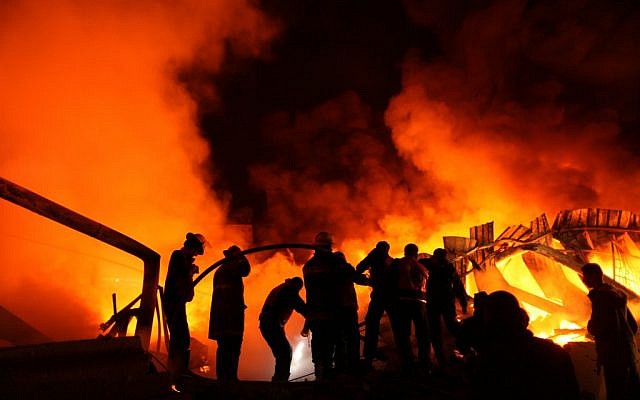 Palestinian firefighters try to extinguish a blaze at a burning factory in Gaza after an Israeli missile strike there Thursday morning. (photo credit: Wissam Nassar/Flash90) Palestinian firefighters try to extinguish a blaze at a burning factory in Gaza after an Israeli missile strike there Thursday morning. (photo credit: Wissam Nassar/Flash90)