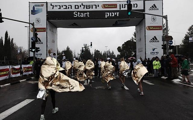 Runners in ponchos at the start of the Jerusalem Marathon (photo credit: Kobi Gideon/Flash90)