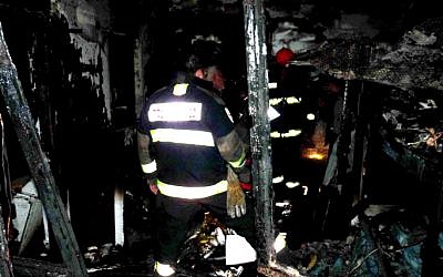 A firefighter examines the debris left over from the Rehovot house fire on Tuesday (photo credit: Yossi Zeliger/Flash90)