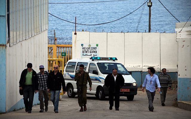 Ahmed Jamal Daif (2nd L), escorted by Israeli officers, arrives at the border crossing between Israel and Lebanon, in March 2012 (photo credit: Avishag Shaar Yashuv/Flash90)