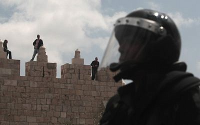 Palestinians watch from Damascus Gate in Jerusalem's Old City as Israeli police and Palestinians clash during a "Land Day" protest on Friday. (photo credit: Kobi Gideon/Flash90)