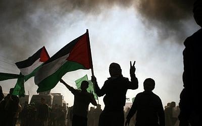 Palestinian protesters waving Palestinian flags during a rally marking Land Day in the northern Gaza strip, near the Erez crossing between Gaza and Israel, Friday (photo credit: Mustafa Mohamad/Flash90)