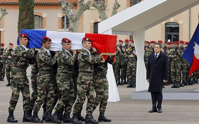 French President Nicolas Sarkozy stands by soldiers carrying a coffin during a ceremony to pay homage to the three soldiers believed killed by Mohamed Merah (photo credit: AP/Jacques Brinon)