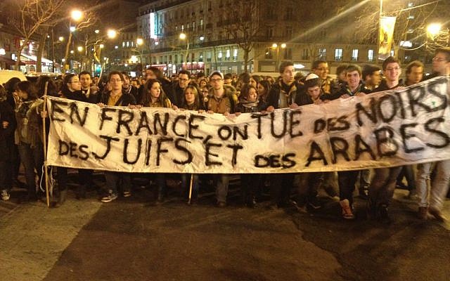 Protesters raising a banner reading "in France, we kill Blacks, Jews, and Arabs" during a silent demonstration in Paris in March. (Photo credit: Daniel Hoffman) Protesters raising a banner reading "in France, we kill Blacks, Jews, and Arabs" during a silent demonstration in Paris in March. (Photo credit: Daniel Hoffman)