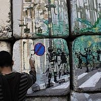An Egyptian artist and activist works on the 'No Walls Street' during the graffiti campaign. (photo credit: AP/Nasser Nasser)