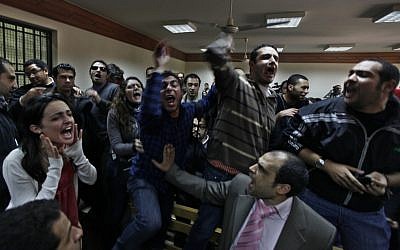 Egyptian protesters during a trial of employees of pro-democracy groups charged with using foreign funds to foment unrest in Cairo. The US may approve funding for Egypt despite its lack of pro-democracy reform. (photo credit: AP/Khalil Hamra)
