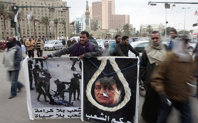 Liberals and Islamists are at the center of a constitutional crisis in Egypt. The protester on the left holds a sign that reads "A nation without dignity is a nation without life." (photo credit: AP/Amr Nabil)