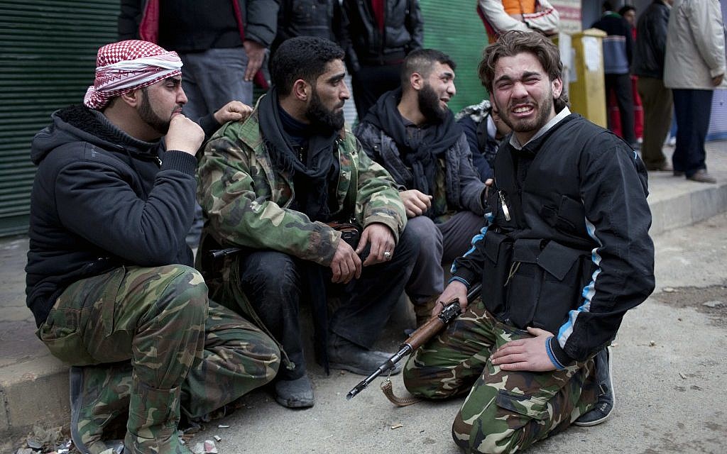 A Syrian rebel reacts after learning about the death of at least four comrades, and several others injured, during clashes with Syrian government forces outside a hospital in Idlib Sunday. In the previous days, troops had encircled the city. (photo credit: Rodrigo Abd/AP) A Syrian rebel reacts after learning about the death of at least four comrades, and several others injured, during clashes with Syrian government forces outside a hospital in Idlib Sunday. In the previous days, troops had encircled the city. (photo credit: Rodrigo Abd/AP)