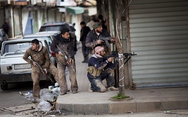 Syrian rebels take position during clashes with Syrian Army forces in Idlib, northern Syria. (photo credit: AP/Rodrigo Abd)