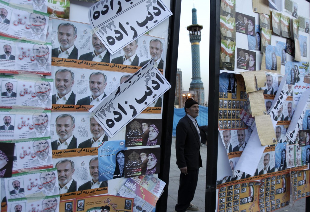 Iranian man looks at electoral posters ahead of Friday's election (AP Photo/Kamran Jebreili)