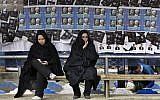 Iranian women surrounded by campaign posters at a bus stop, March 1, 2012 (photo credit: AP Photo/Vahid Salemi)