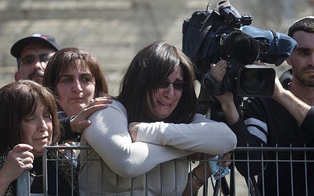 Eva Sandler weeps during the Jerusalem funeral of her husband and two young sons on Wednesday (photo credit: AP Photo/Sebastian Scheiner) Eva Sandler weeps during the Jerusalem funeral of her husband and two young sons on Wednesday (photo credit: AP Photo/Sebastian Scheiner)