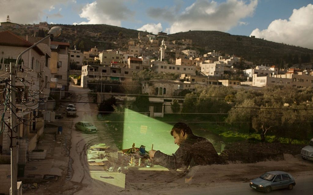 Palestinian calligraphy expert Adel Fauzy practices at his studio in the West Bank town of Hawara, near Nablus. (photo credit: AP/Bernat Armangue) Palestinian calligraphy expert Adel Fauzy practices at his studio in the West Bank town of Hawara, near Nablus. (photo credit: AP/Bernat Armangue)