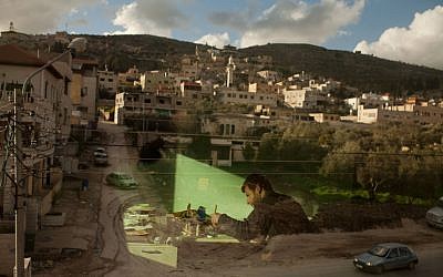 Palestinian calligraphy expert Adel Fauzy practices at his studio in the West Bank town of Hawara, near Nablus. (photo credit: AP/Bernat Armangue)
