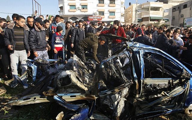 Palestinians gather around the wreckage of Zuhair al-Qaissi's car in Gaza, on Friday. (photo credit: AP photo/Hatem Moussa) Palestinians gather around the wreckage of Zuhair al-Qaissi's car in Gaza, on Friday. (photo credit: AP photo/Hatem Moussa)
