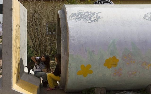Israeli children play outside a sewage pipe which is ready to be used as a protective shelter in Nitzan, near Ashdod, Sunday. (photo credit: AP)