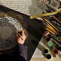 Palestinian calligraphy expert Adel Fauzy practices at his studio in the West Bank town of Hawara, near Nablus. (photo credit: AP/Bernat Armangue)