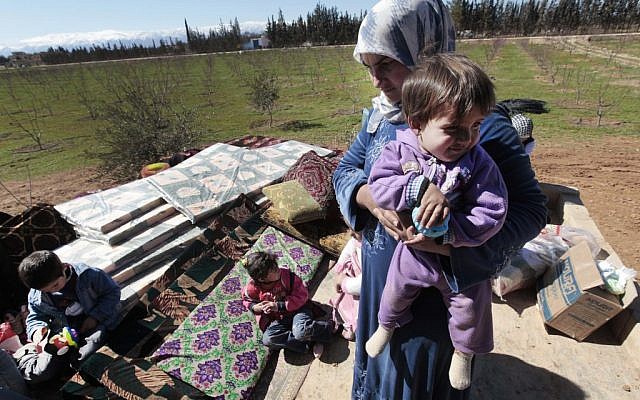 Syrian refugees by the Lebanese border (photo credit: AP/Hussein Malla)