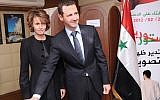Syrian President Bashar Assad casts his ballot next to his wife Asma at a polling station during a referendum last year on a new constitution, in Damascus. (photo credit: AP Photo/SANA, File)