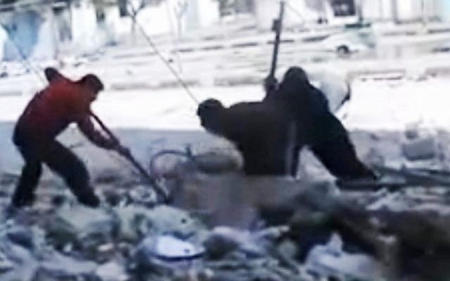 This screen capture, taken from an amateur video in Homs, shows Syrians pulling out a man's body from the rubble of a building after it was bombed last week. (photo credit: Syria Media Center via APTN/AP)