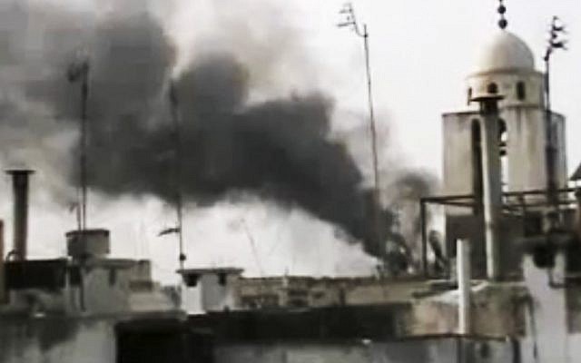 This image made from amateur video and released by Shaam News Network Monday, March 26, 2012, purports to show smoke rising from buildings in Homs, Syria (photo credit: AP/Shaam News Network via APTN) This image made from amateur video and released by Shaam News Network Monday, March 26, 2012, purports to show smoke rising from buildings in Homs, Syria (photo credit: AP/Shaam News Network via APTN)