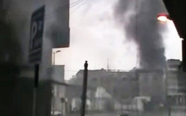 File: A screen capture from amateur video purporting to show black smoke rising from buildings that were fired upon in Homs. Syrian President Bashar Assad says he will spare no effort to make the mission of UN-Arab League envoy Kofi Annan a success but he demands that armed opponents commit to halting violence. (photo credit: Syria Media Center via APTN/AP)