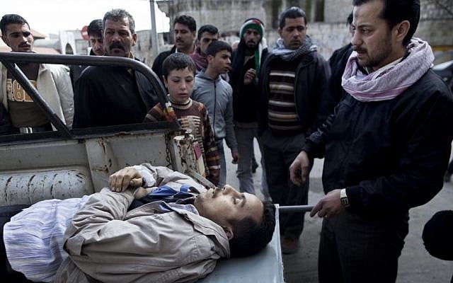 Residents gather around the body of Mohammed Halak, killed during fighting between Free Syrian Army fighters and the Syrian Army in Idlib, north Syria (photo credit: AP Photo/Rodrigo Abd) Residents gather around the body of Mohammed Halak, killed during fighting between Free Syrian Army fighters and the Syrian Army in Idlib, north Syria (photo credit: AP Photo/Rodrigo Abd)