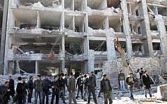 Syrian security officers in front of the damaged building of the aviation intelligence department, which was attacked by one of two explosions in Damascus on Saturday (photo credit: AP/Bassem Tellawi)