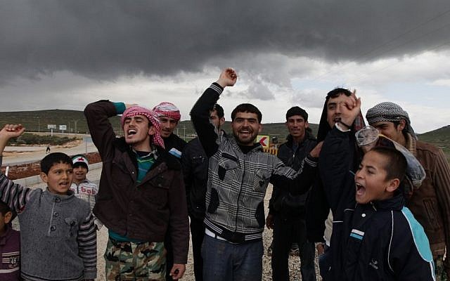 Newly arrived Syrian refugees, who fled the violence in their country, demonstrate at the border in Reyhanli, Turkey in March. (photo credit: AP)