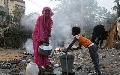 An Indian woman and her daughter carry a bucket of water in the streets of Pushkar Rajasthan (photo credit: Liron Almog/Flash90)