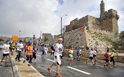 Runners sloshing by the Old City in the 2012 Jerusalem Marathon. (photo credit: Yoav Ari Dudkevitch/ Flash90)
